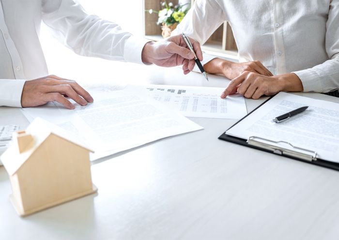 Zwei Personen mit Papieren auf dem Tisch